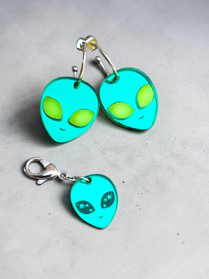 Morti's Fun Club alien face earrings in cosmic mirror acrylic with lime fluorescent eyes and silver-plated hoops.