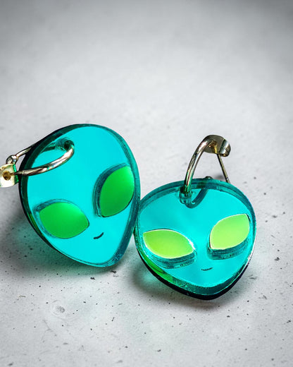 Morti's Fun Club alien face hoop earrings in teal mirrored acrylic with fluorescent lime green eyes.
