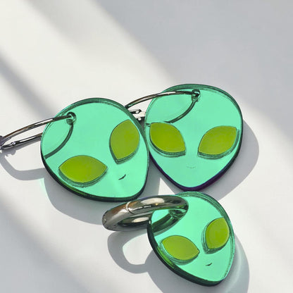 Morti's Fun Club green acrylic alien hoop earrings and matching dog collar charm set on a light blue background