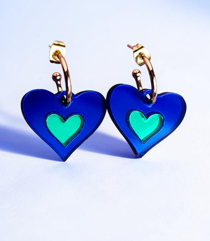 Morti's Fun Club I Heart Dogs heart-shaped earrings in royal blue and green mirrored acrylic with gold hoops.