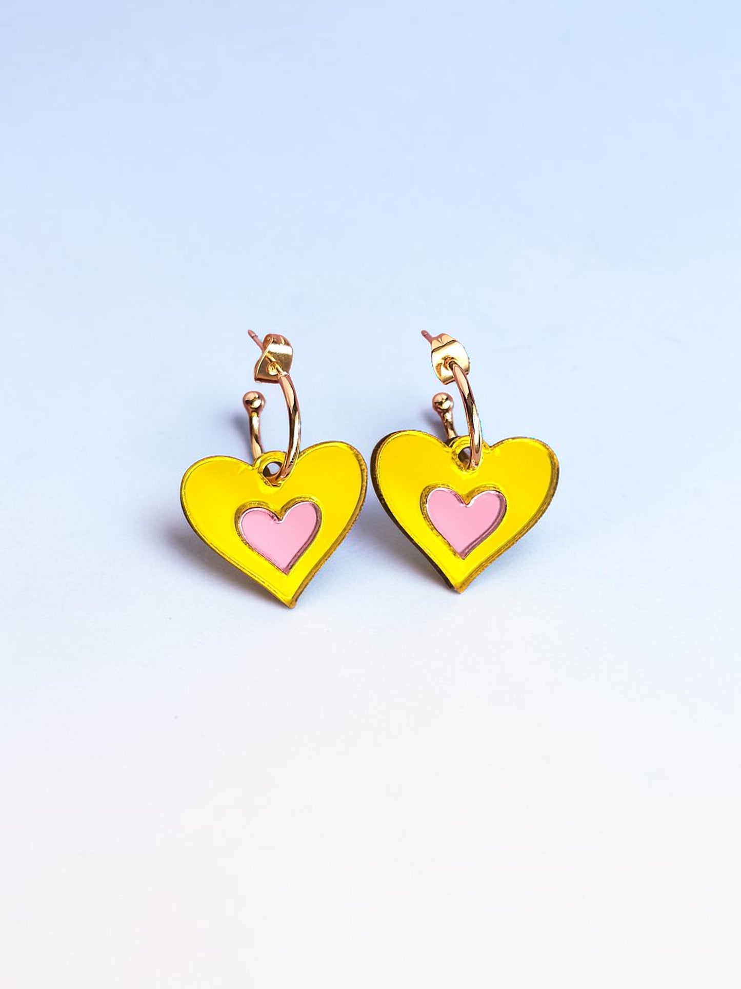 Morti's Fun Club Candy Canary heart earrings in yellow and pink mirrored acrylic with gold-plated hoops.
