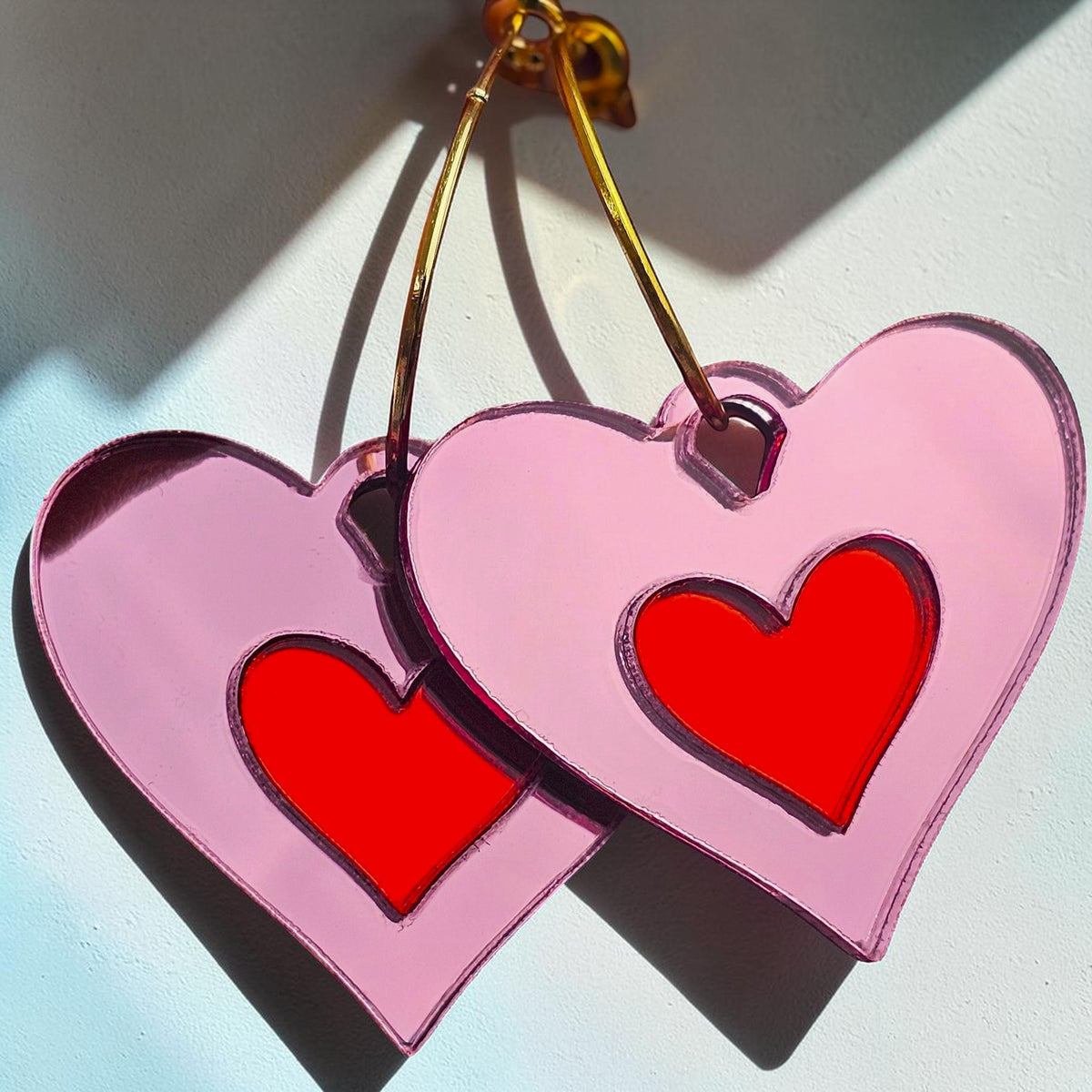 Morti's Fun Club Cherry Blossom heart earrings with pink acrylic and red inlaid centres on silver-plated hoops.