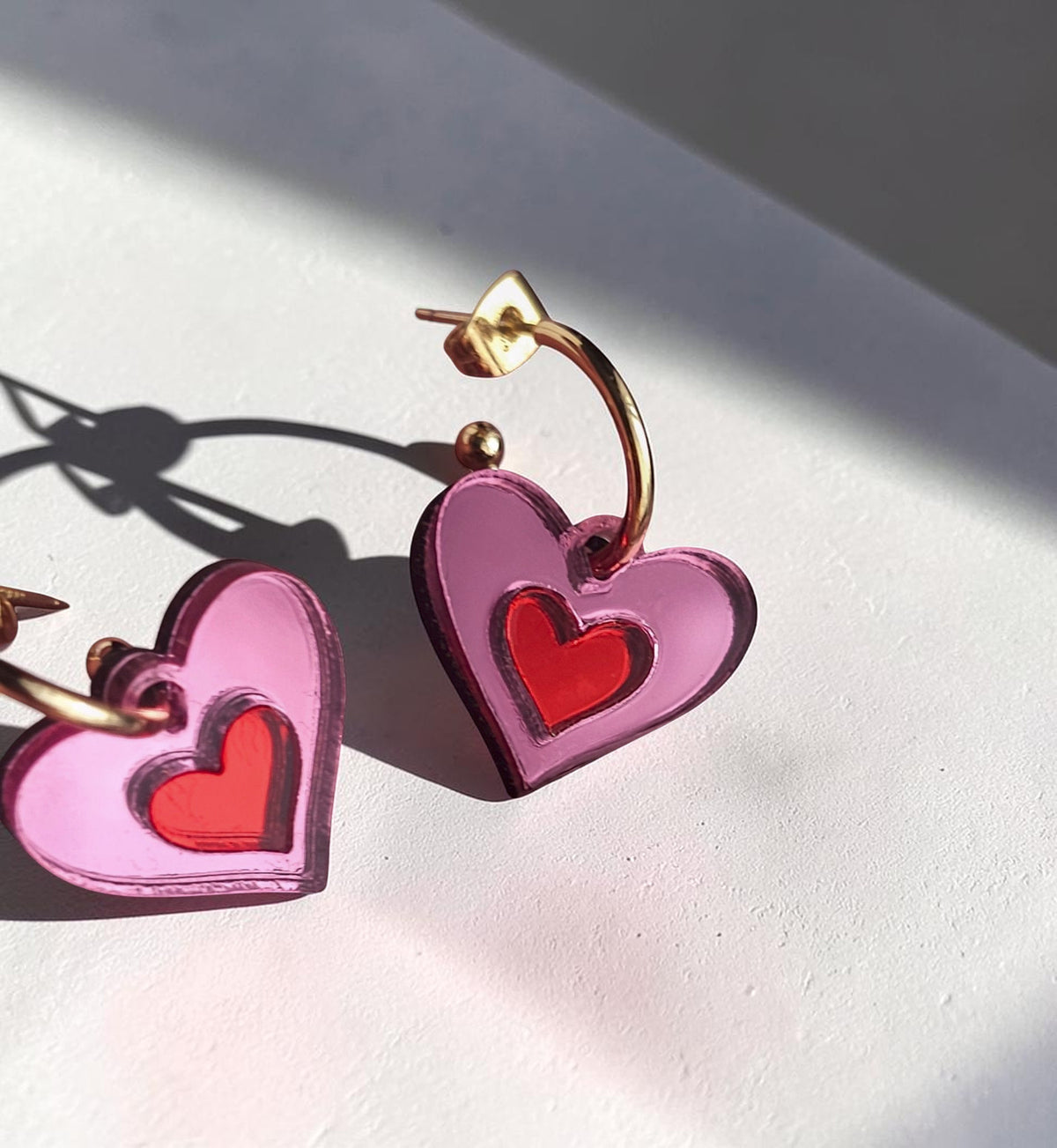 Morti's Fun Club Cherry Blossom heart earrings in pink and red mirrored acrylic with gold-plated hoops.