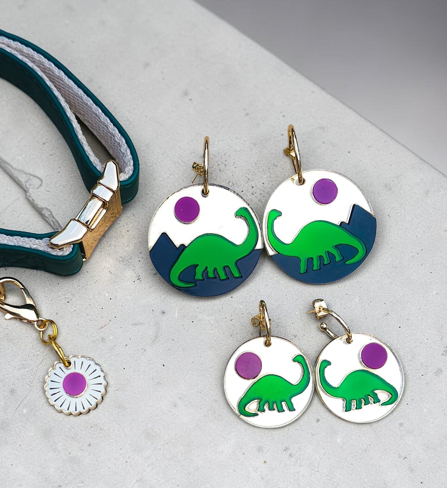 Morti's Fun Club Tiny Dino earrings featuring green dinosaurs on gold and black acrylic discs with gold-plated hoops