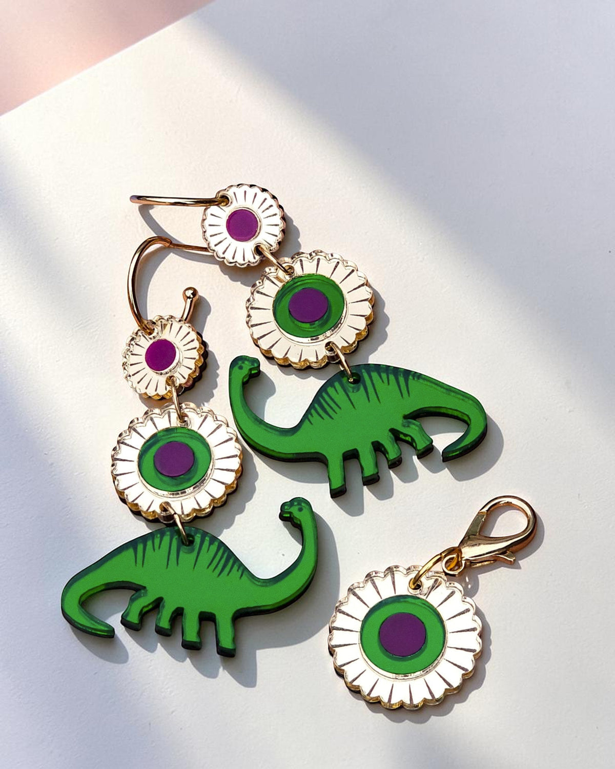Morti's Fun Club Dino Royalty twinning set with green dinosaur earrings and a matching floral dog collar charm.
