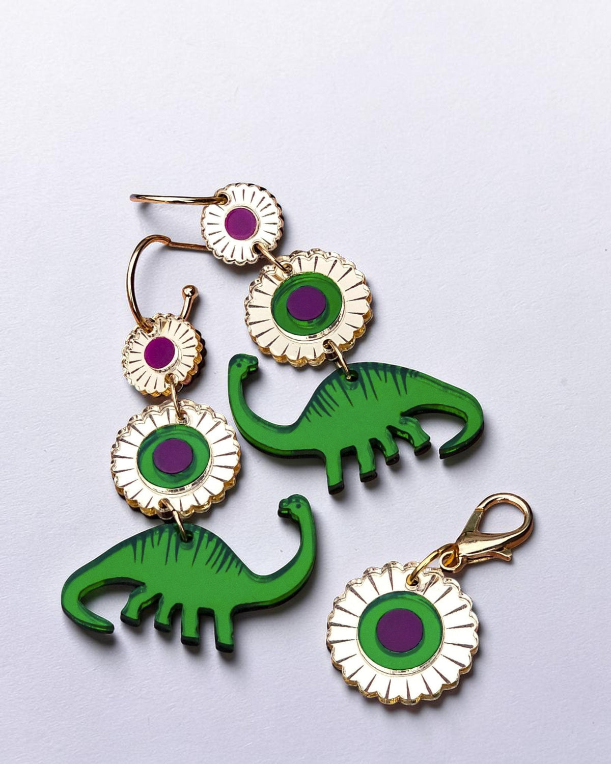 Morti's Fun Club Jurassic Bloom charm and earrings featuring green acrylic dinosaurs and purple floral accents.