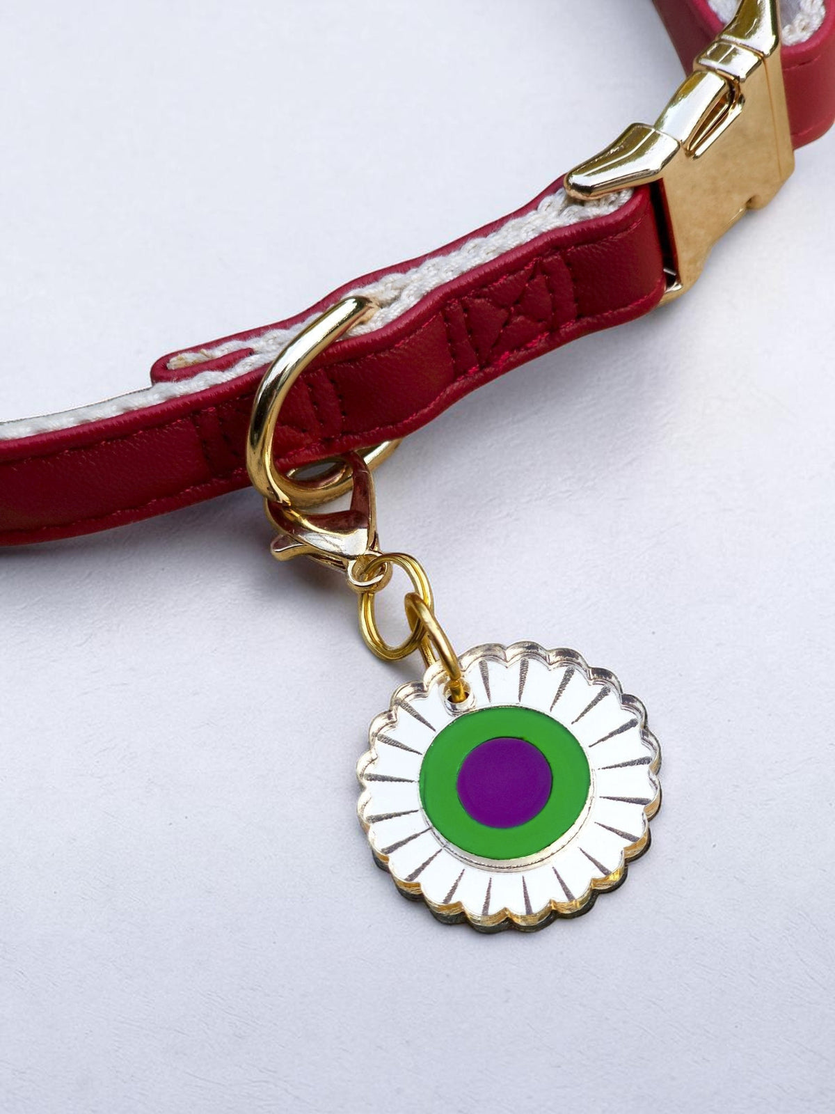 Morti's Fun Club mirror acrylic flower collar charm with green and purple center on a red dog collar