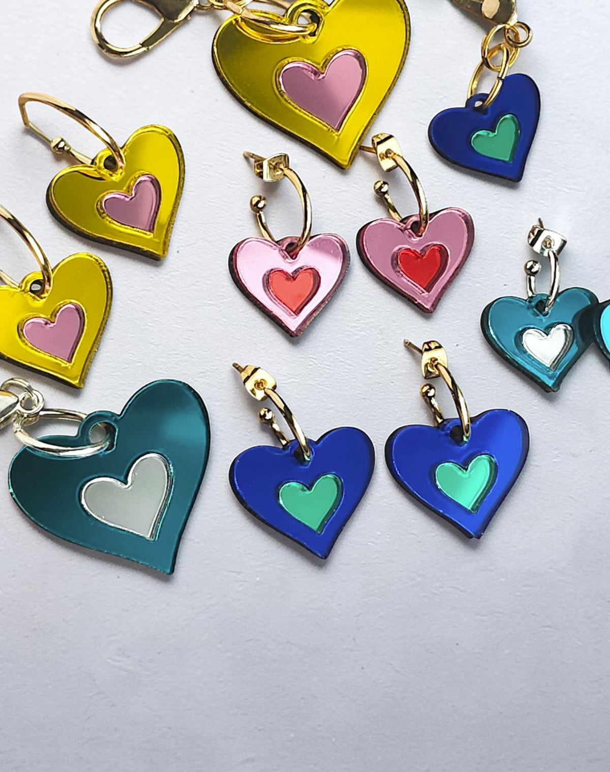 Morti's Fun Club I Heart Dogs heart-shaped mirrored acrylic earrings in various bright colourways with gold hoops.