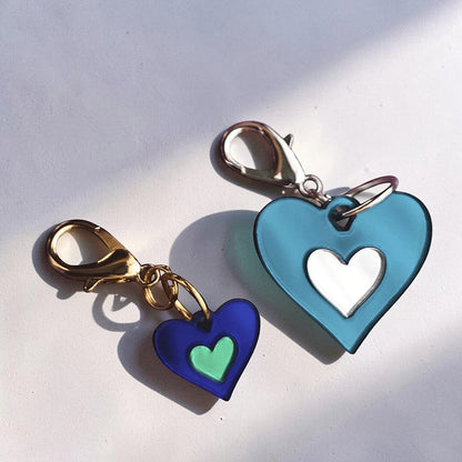 Morti's Fun Club heart-shaped acrylic dog collar charms in royal blue and teal with gold and silver lobster clips.