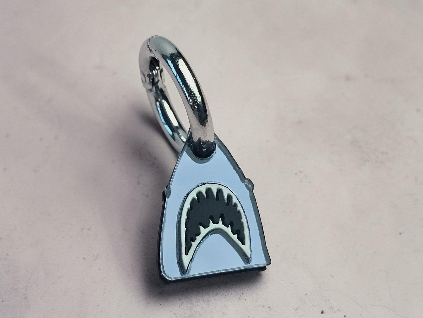 Morti's Fun Club shark dog collar charm in mirrored silver acrylic with black and white shark teeth detail.