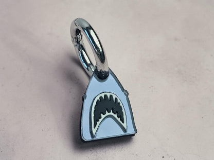Morti's Fun Club shark dog collar charm in mirrored silver acrylic with black and white shark teeth detail.