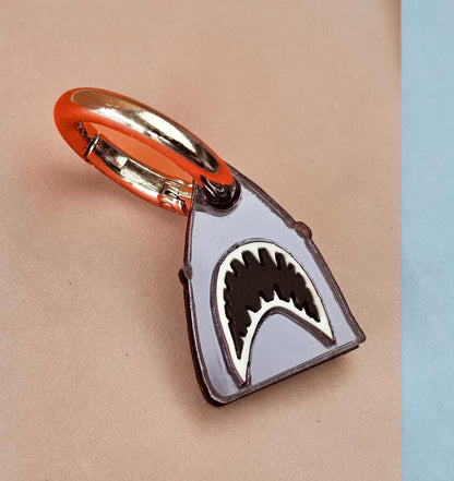 Morti's Fun Club shark dog collar charm in mirrored silver acrylic with black and white shark teeth detail.