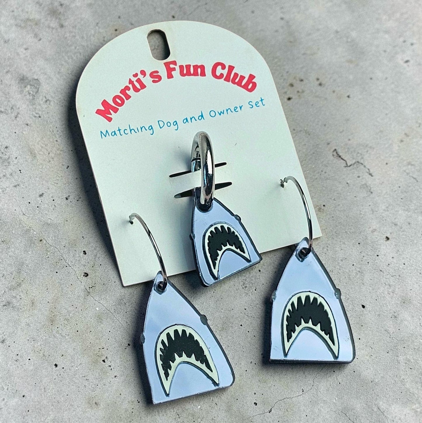 Morti's Fun Club Bite Me shark twinning set featuring mirrored silver acrylic earrings and a matching dog collar charm