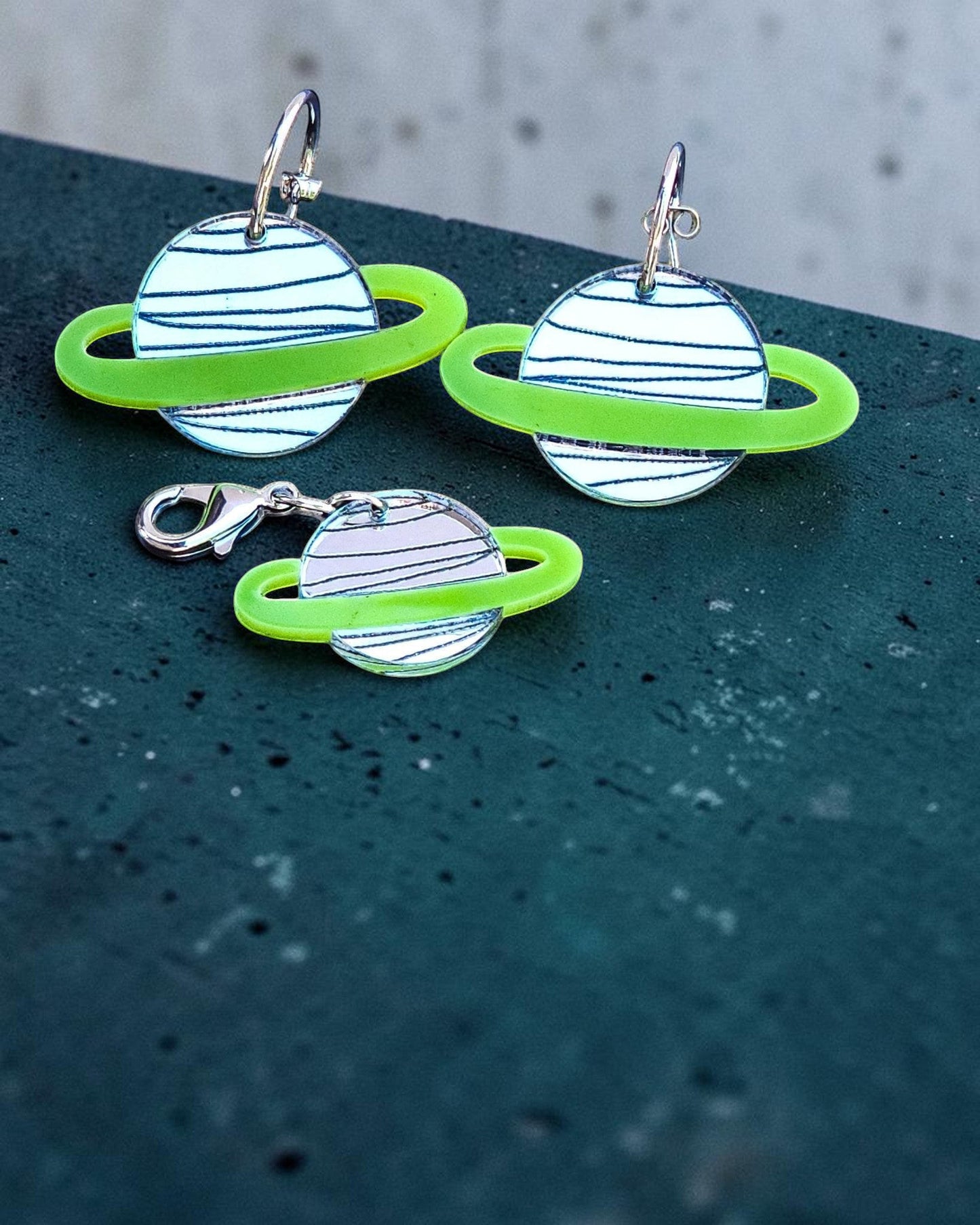 Morti's Fun Club Solar System twinning set featuring green and silver acrylic planet earrings and a matching charm.