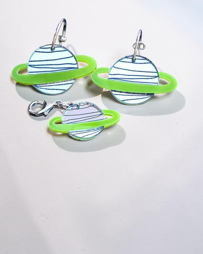 Morti's Fun Club Solar System twinning set featuring green and silver acrylic planet earrings and a matching charm.