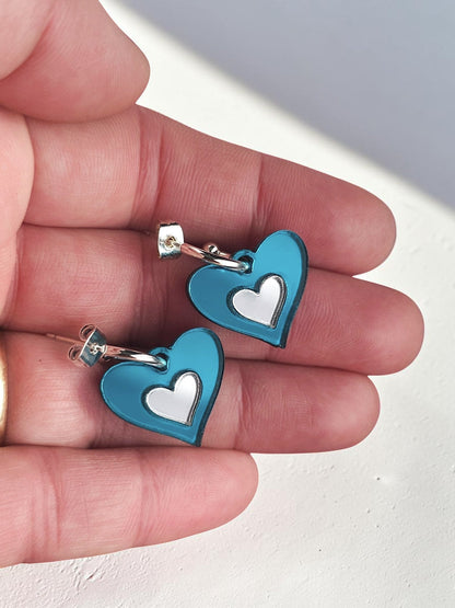 Morti's Fun Club Ice Queen heart earrings featuring shimmering teal acrylic and silver inlay on silver-plated hoops.