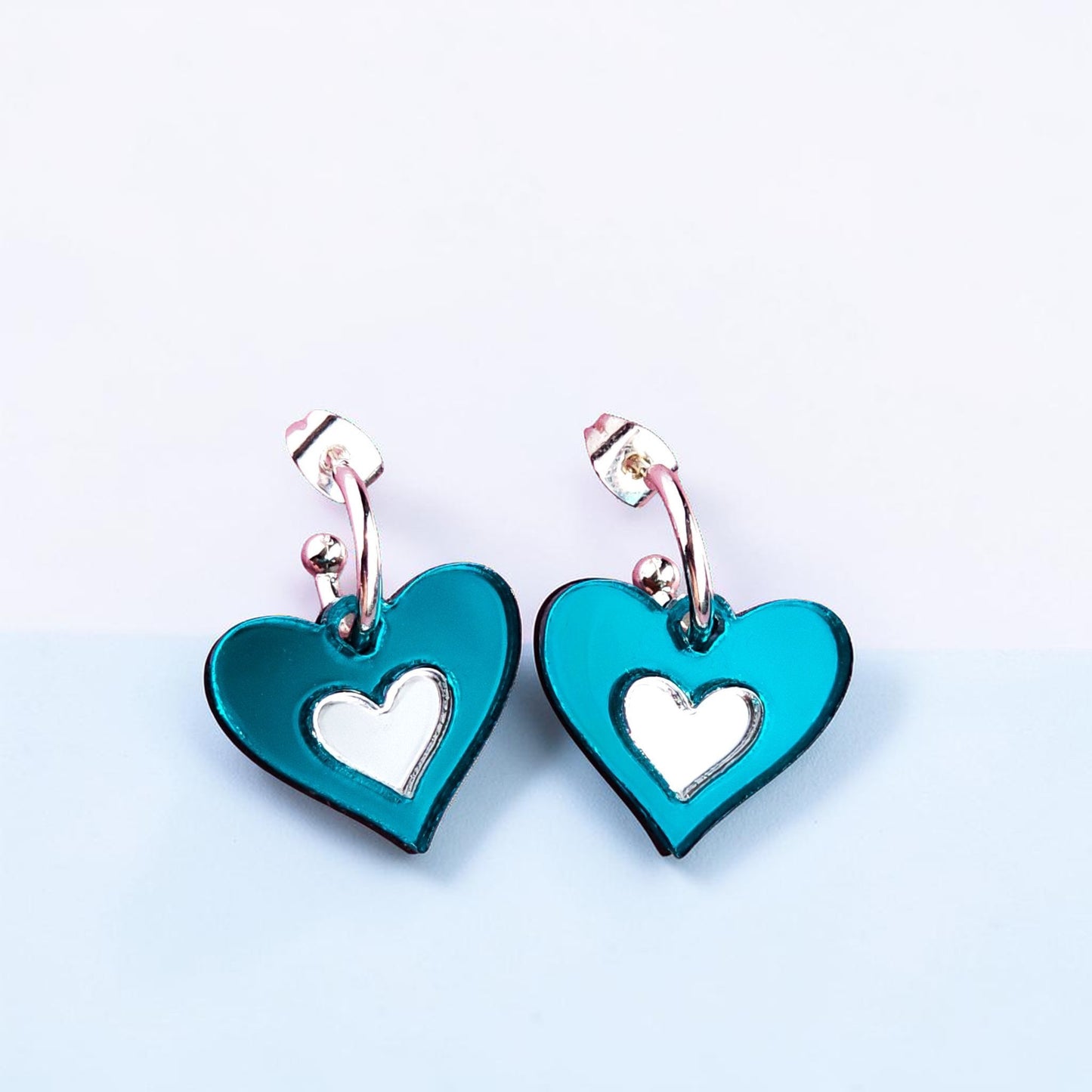 Morti's Fun Club Ice Queen heart earrings in teal and silver mirrored acrylic with hypoallergenic silver hoops.