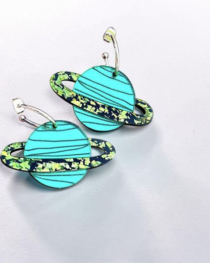 Morti's Fun Club teal mirrored acrylic planet earrings with lime glitter rings on gold-plated hoops.